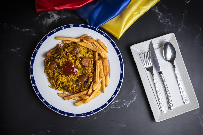 Arroz con chorizo, pollo y cerdo. con maduro frito y patatas fritas